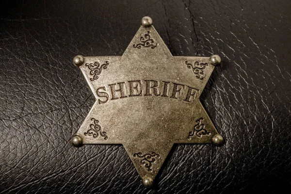 Sheriff-Abzeichen auf schwarzem Leder Textur Hintergrund. — Stockfoto