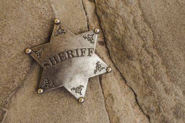 Doğal taş zemin üzerine şerif rozeti.