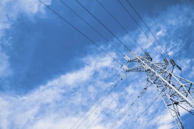 Yüksek gerilim güç dikmesi karşı bulut ile mavi gökyüzü.