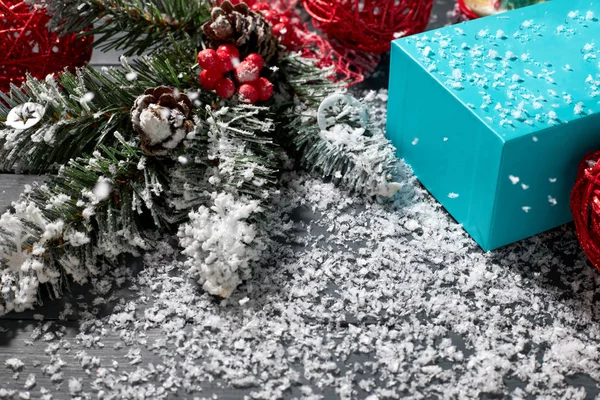 Noel süsü ve mavi hediye kutusu karla kaplı bir masanın üzerinde. Noel kompozisyonu.