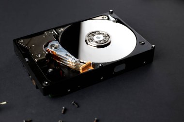 Bilgisayardan parçalanmış hard disk. Ayna efektli kapak. Siyah yüzey üzerinde açılan sabit disk.