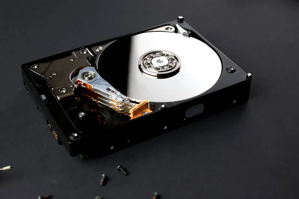 Bilgisayardan parçalanmış hard disk. Ayna efektli kapak. Siyah yüzey üzerinde açılan sabit disk.