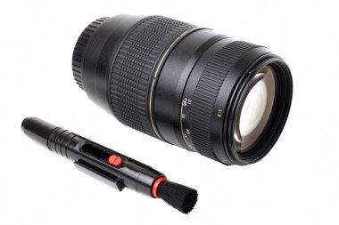 Beyaz arka planda izole edilmiş optikler için fotoğraf merceği ve temizlik fırçası. Fırça ve seyahat zoom optiği ile mercek.