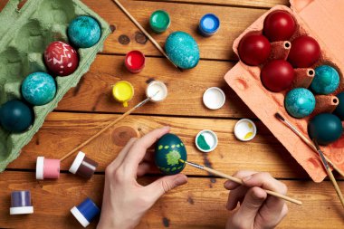 Mutlu Paskalyalar! Kadının elleri Paskalya günü için yumurta boyuyor. Paskalya için hazırlanıyorum. Üst görünüm.