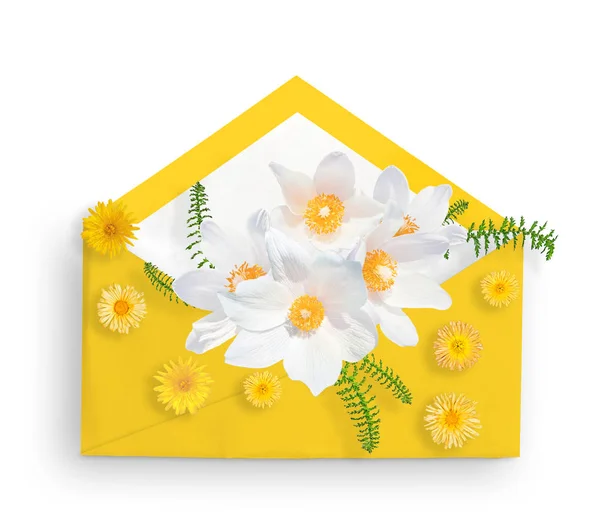 White snowdrops in yellow envelope and yellow small flowers. Flat lay. Top view. Spring card