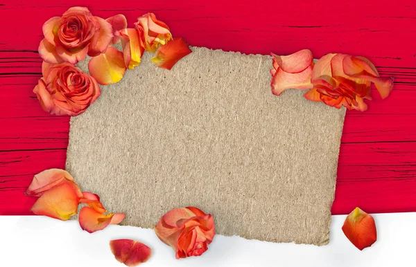 Red roses on red wooden background. Flat lay