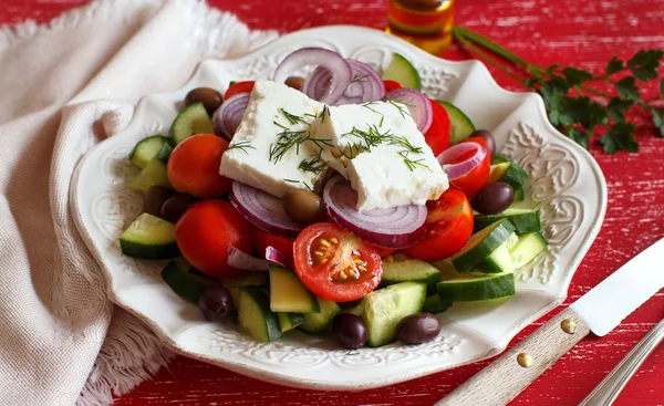 Griechischer Salat auf rotem Hintergrund — Stockfoto