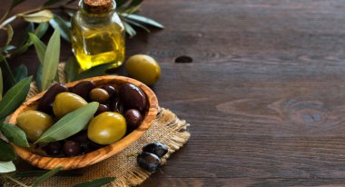 Zeytinyağı ve zeytin ahşap arka plan üzerinde