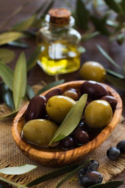 Zeytinyağı ve zeytin ahşap arka plan üzerinde