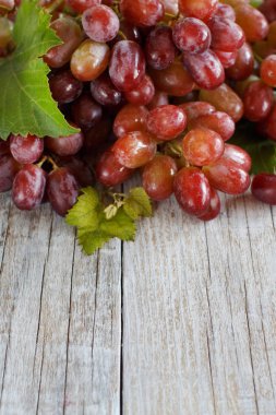 Eski ahşap bir masa üzerinde kırmızı üzüm
