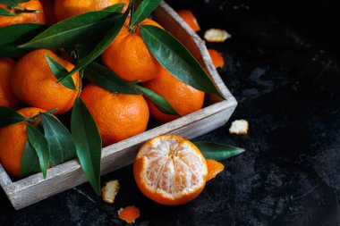 Bir kutu içinde yapraklarla mandalina