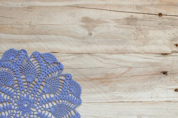 Eski ahşap masa üzerinde mavi tığ işi bardak altlığı peçete — Stok fotoğraf
