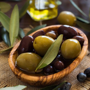 Zeytinyağı ve zeytin ahşap arka plan üzerinde