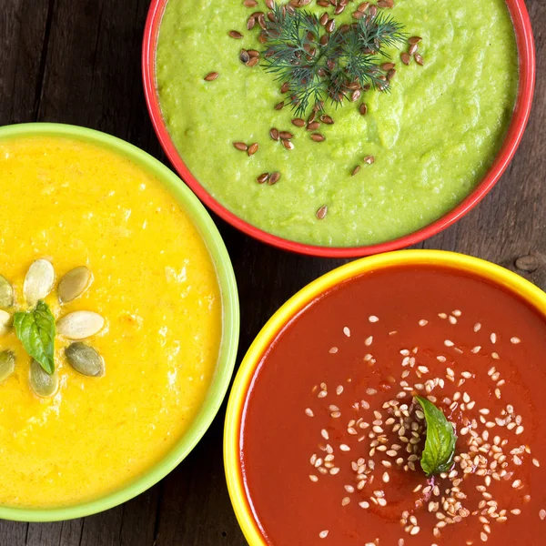 Three fresh soups on a wooden table — Stock Photo, Image