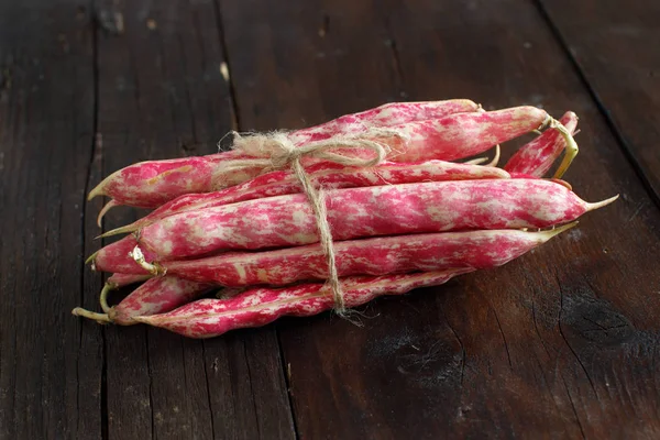 Fagioli con baccelli su un tavolo di legno — Foto Stock