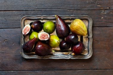 Bir tepsi üzerinde yeşil ve mor incir