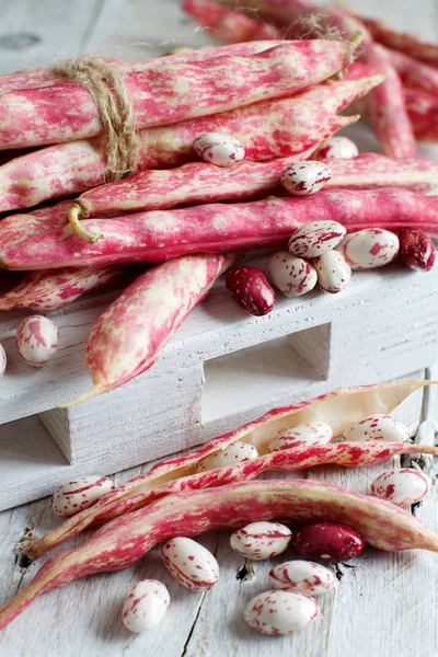 Fagioli con baccelli su un tavolo di legno — Foto Stock