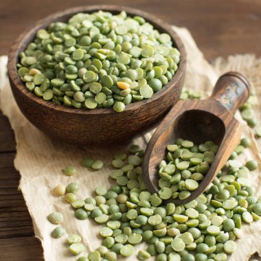 Bir kaşık ile bir kase içinde pişmemiş yeşil bezelye 