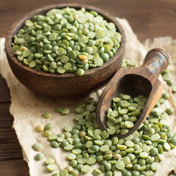 Bir kaşık ile bir kase içinde pişmemiş yeşil bezelye 