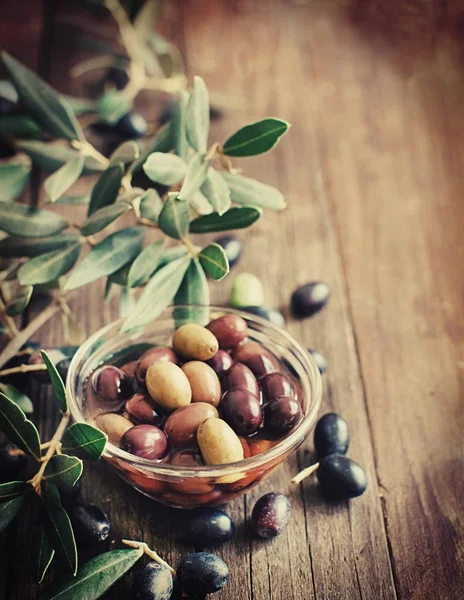 Fresh olives and olive branch on wood background — Stock Photo, Image