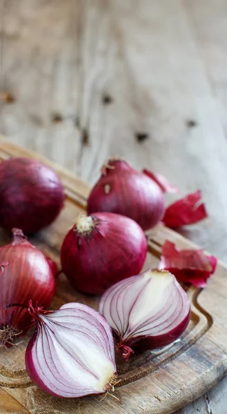 Red onions on a wooden board — Stock Photo, Image