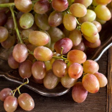 Ahşap bir zemin üzerine gümüş tepsi üzerinde üzüm