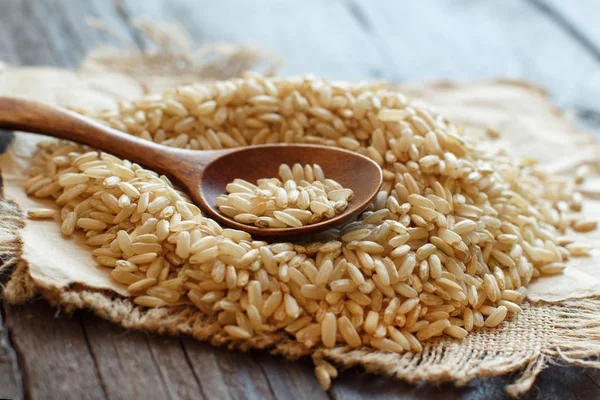 Kahverengi pirinç bir tahta kaşıkla yığını — Stok fotoğraf