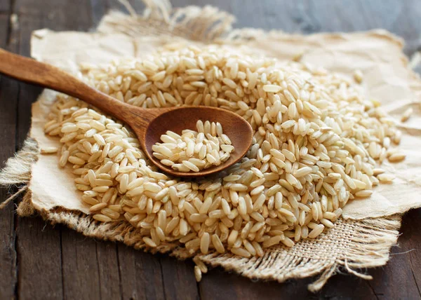 Montón de arroz integral con una cuchara de madera — Foto de Stock