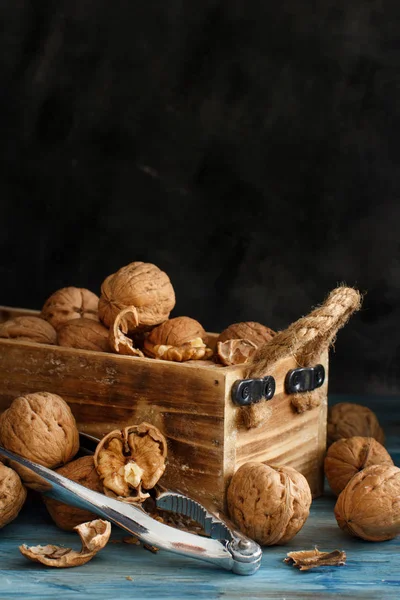 Fresh walnuts in a box on a blue wooden table — Stock Photo, Image
