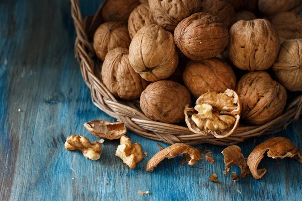 Čerstvé vlašské ořechy na modré dřevěný stůl — Stock fotografie