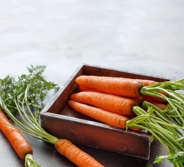 Zanahorias frescas crudas con hojas en una caja — Foto de Stock