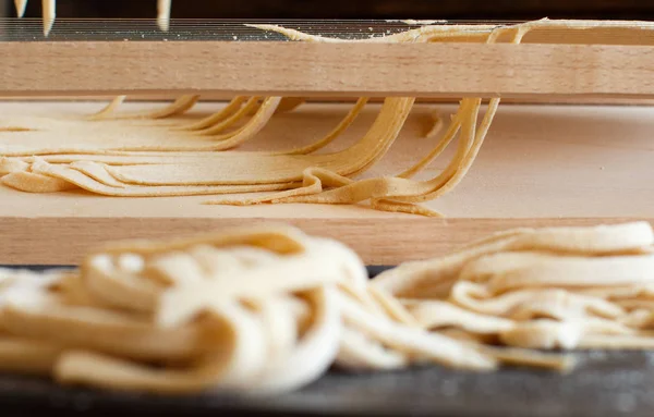 Making tagliolini pasta alla chitarra with a tool — Stock Photo, Image