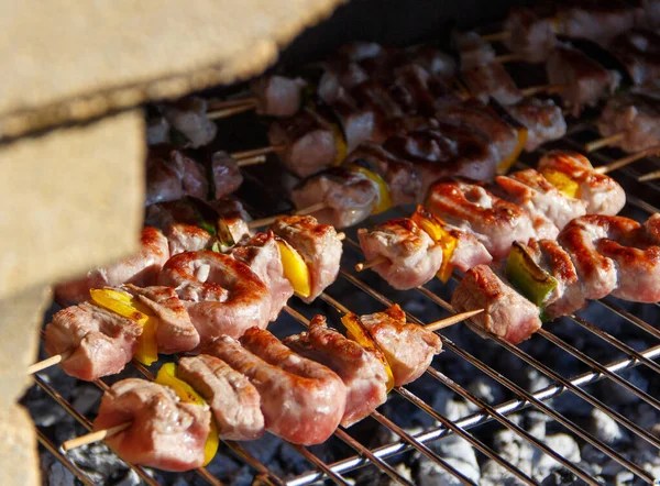 Brochettes de viande et de saucisses cuisant sur un gril — Photo