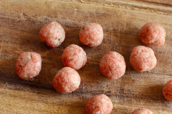 Rauwe gehaktballen klaar om te koken op een houten plank — Stockfoto