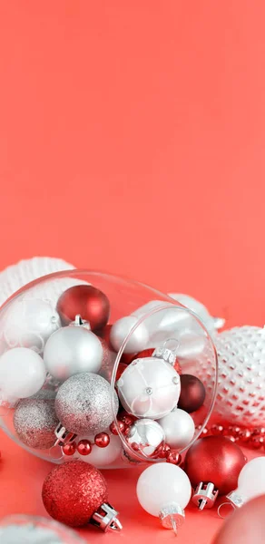 Christmas baubles in a wine glass on a red background — Stock Photo, Image