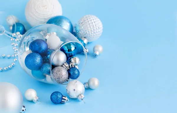 Bola de Navidad en una copa de vino sobre un fondo azul claro — Foto de Stock