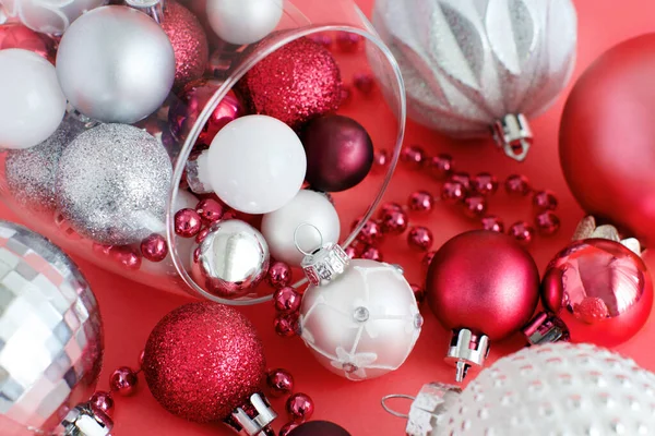 Christmas baubles in a wine glass on a red background — Stock Photo, Image