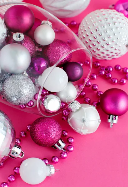 Christmas baubles in a wine glass on a pink background — Stock Photo, Image