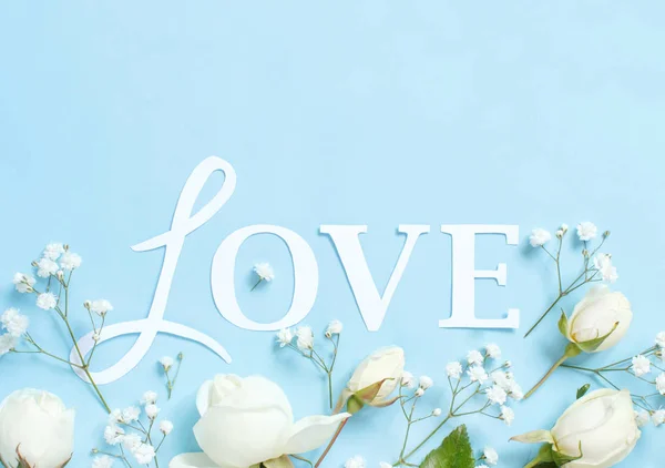Fiori e parola Amore su sfondo azzurro — Foto Stock