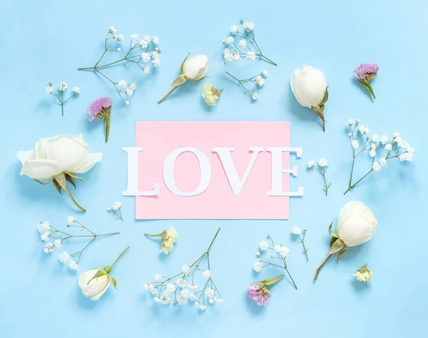 Flowers and word LOVE on a light blue background — Stock Photo, Image