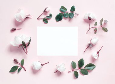 Açık pembe arka planda çiçekler ve kağıt