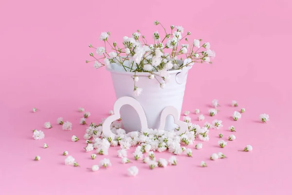 Pequeñas flores blancas y corazones sobre un fondo rosa — Foto de Stock