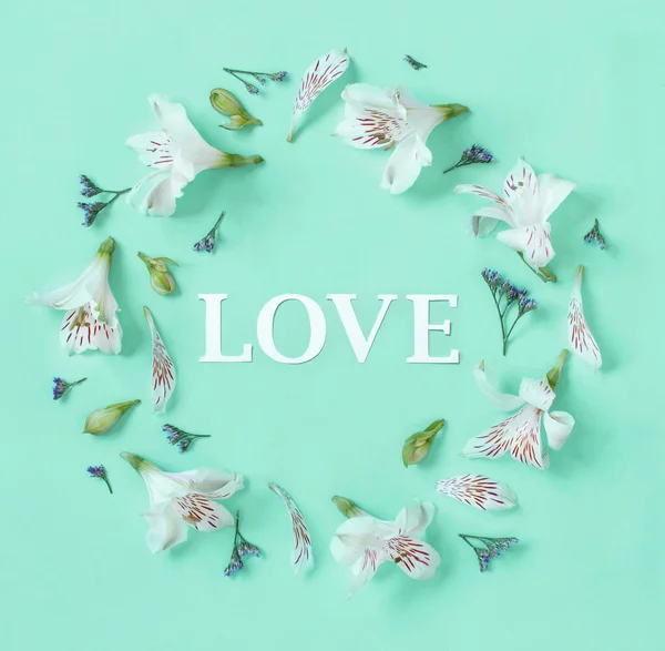 Flores y palabra Amor sobre un fondo verde claro — Foto de Stock