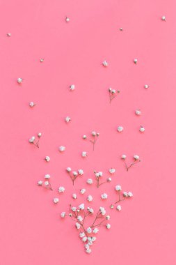 Açık pembe arkaplanda küçük beyaz çiçekler