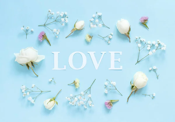 Flowers and word LOVE on a light blue background — Stock Photo, Image