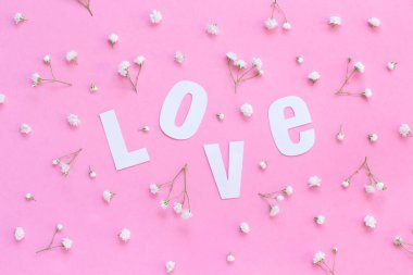 Açık pembe arka planda çiçekler ve aşk yazıları