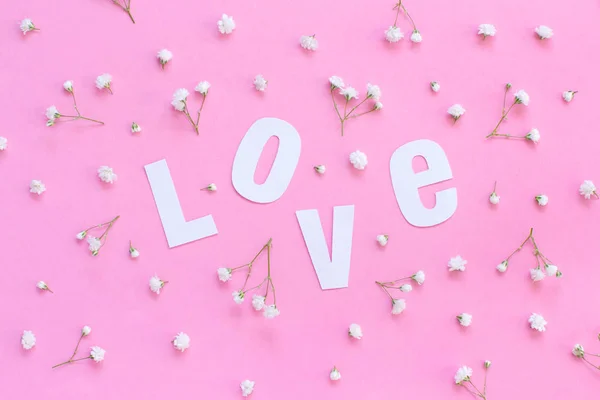 Flores e amor lettering em um fundo rosa claro — Fotografia de Stock