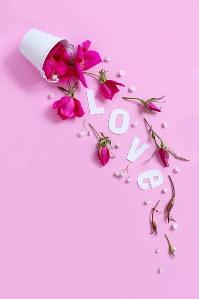 Composição de primavera com flores rosa e texto AMOR caindo de — Fotografia de Stock