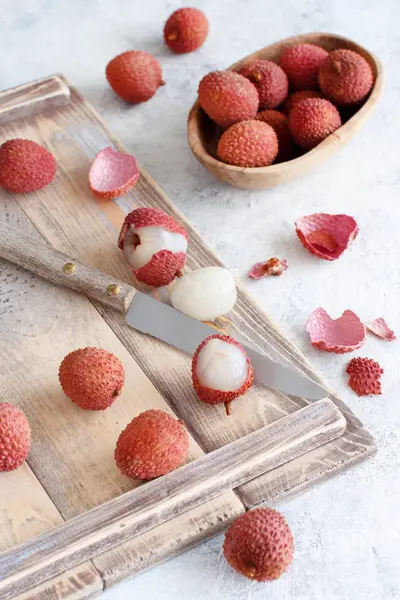 Fruits litchi frais avec un couteau sur une table blanche — Photo