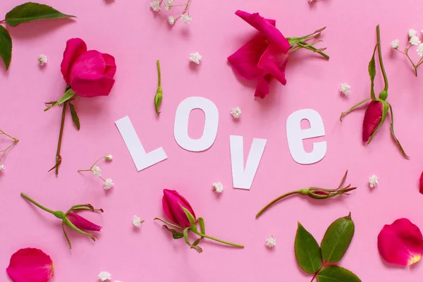 Pink roses and text LOVE on a light pink background — Stock Photo, Image